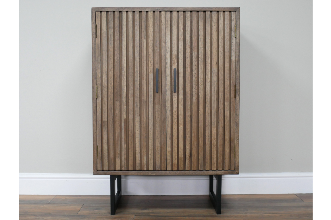 2 door slatted cabinet in natural wood finish with black metal legs, front view against plain wall background.
