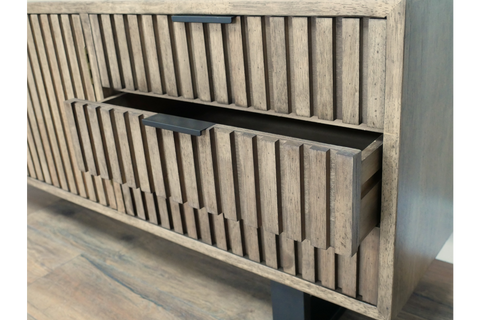 Wooden TV low sideboard slatted cabinet in light brown with black handle, open drawer detail, angled view.