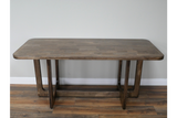 Rectangular wooden dining table with rounded corners, visible wood grain, and geometric leg design, front view.
