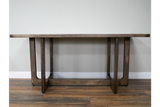 Rectangular dining table with dark wooden top and sturdy legs, shown from the front against a plain wall.