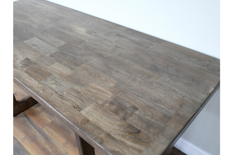 Rectangular wooden dining table with a smooth, dark grey-brown top, shown from a high angle in a room.