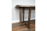 Wooden dining table with rectangular top and sturdy square legs, angled close-up view on wooden floor.