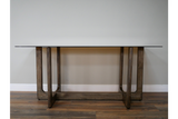 Rectangular dining table with clear glass top and dark wooden U-shaped legs, front view on wooden floor.