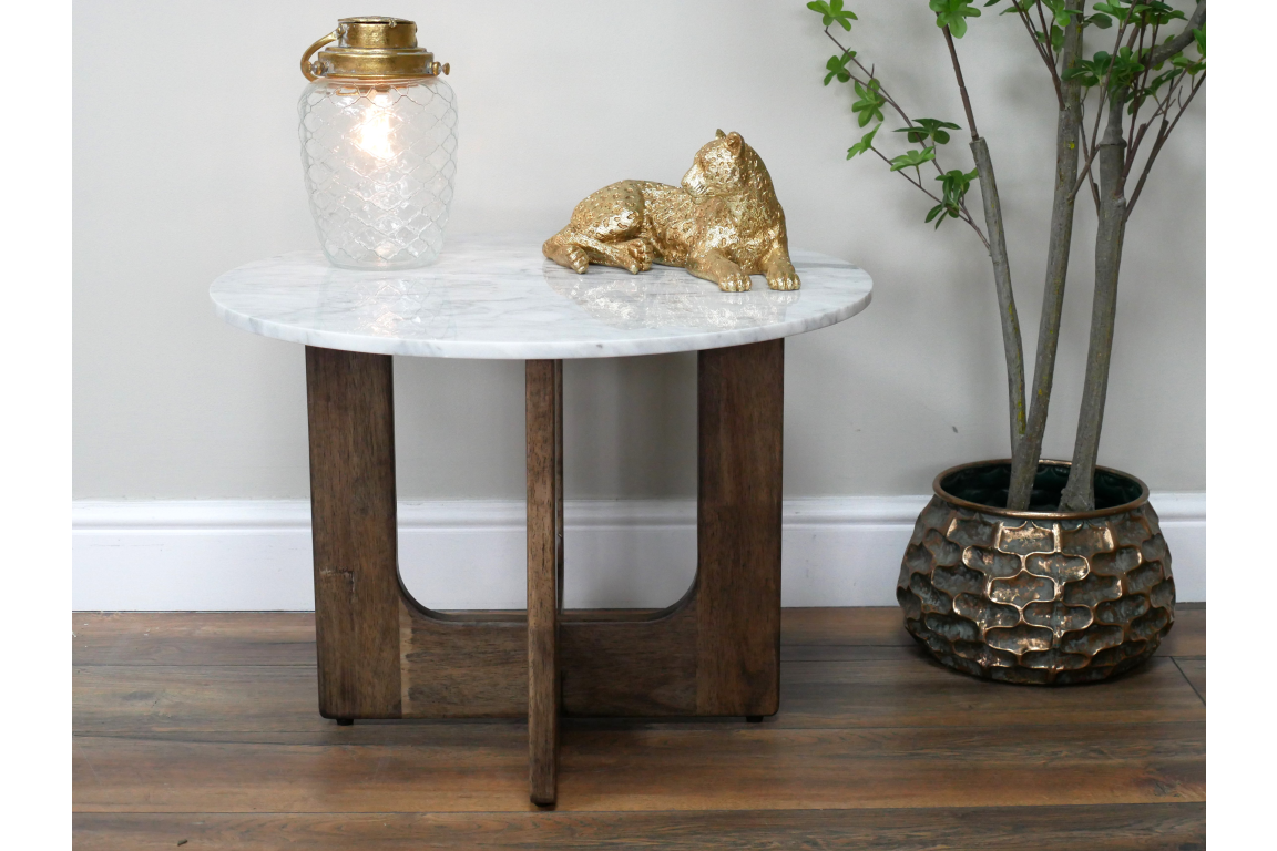 Round marble top side table with dark wooden base, shown from front with decorative lamp and gold cat figurine on top.
