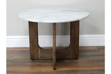 Round marble top side table with dark wooden legs, shown from front on hardwood floor against white wall.