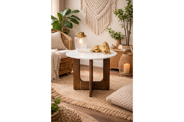 Round marble top side table with dark wooden base, shown in warm boho living room setting, front angle.