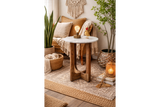 Small side table with round white marble top and dark wood U-shaped legs in cozy living room corner.
