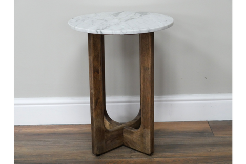Small round side table with white marble top and dark brown wooden legs, shown from front angle on wood floor.