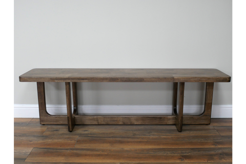 Long wooden bench with a dark brown finish, rectangular top, and sturdy U-shaped legs, shown from front on wooden floor.
