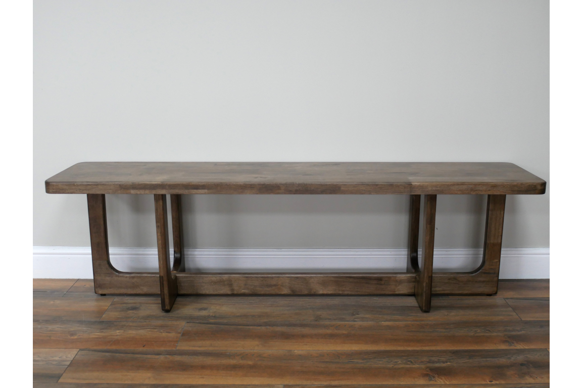 Long wooden bench with a dark brown finish, rectangular top, and sturdy U-shaped legs, shown from front on wooden floor.