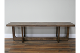 Long wooden bench with a dark brown finish, rectangular top, and sturdy U-shaped legs, shown from front on wooden floor.