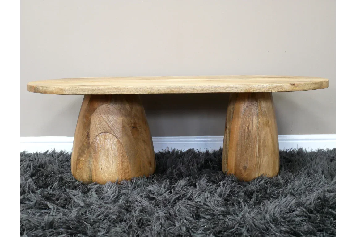 Solid wood coffee table with twin pedestal base on grey shaggy rug