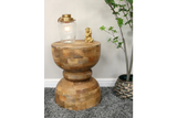 Solid wood side table with rounded base, lamp, gold ornament, grey rug and indoor plant