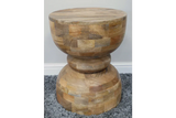 Round solid wood side table with natural finish on grey carpet
