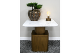 Square side table with white marble top and bronze metal base, decorated with a small plant and light bulb on top.