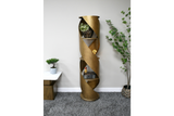 Tall gold metal swirl display cabinet with three shelves, shown in a minimalist room setting from the front angle.