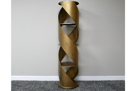 Tall swirl display cabinet in bronze metal with spiral design and three shelves, standing against a plain wall on gray
