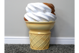 Ice cream cone-shaped side table with white and brown swirl top, yellow cone base, photographed on gray carpet near wall
