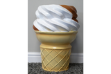 Beige and white plastic side table shaped like a soft serve ice cream cone, shown from the front on a carpeted floor.