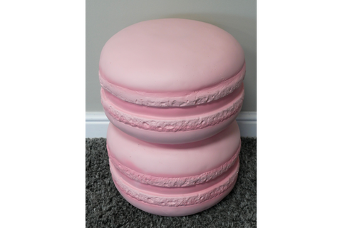 Pink macaron-shaped side table with textured edges, shown from an angled top view on gray carpet.