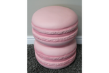 Pink macaron-shaped side table with textured edges, shown from an angled top view on gray carpet.