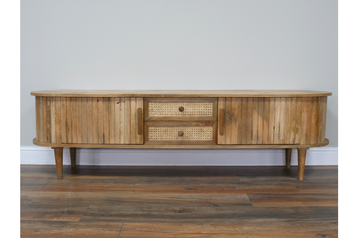 Wooden TV cabinet with rounded edges, slatted doors, cane drawer fronts, and tapered legs, front view.