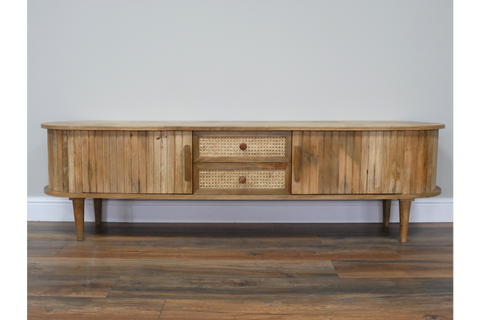 Wooden TV cabinet with rounded edges, slatted doors, cane drawer fronts, and tapered legs, front view.