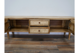 Wooden TV cabinet with two open side doors and two front drawers featuring woven rattan panels, front view.