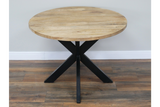 Round dining table with natural wood top and black metal X-shaped base, front view on wooden floor