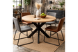 Round dining table with natural wood top and black metal crossed base, shown with mixed grey and brown chairs on woven rug.