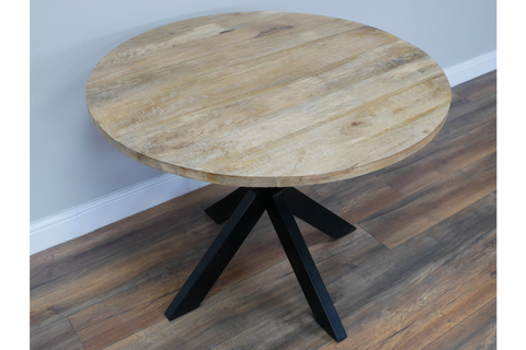 Round dining table with natural wood top and black angled metal legs, shown from a slight overhead angle.