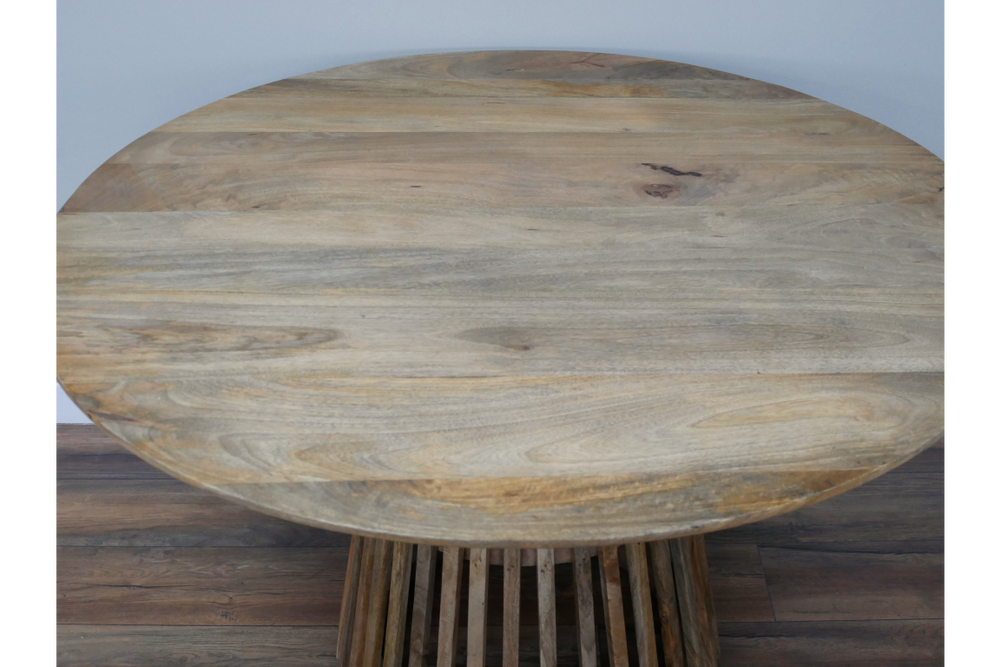 Round wooden dining table with slatted base in natural light brown finish, viewed from above.