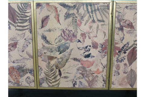 Large cabinet with three doors, gold frame, and multi-colored leaf pattern on textured surface, front view.