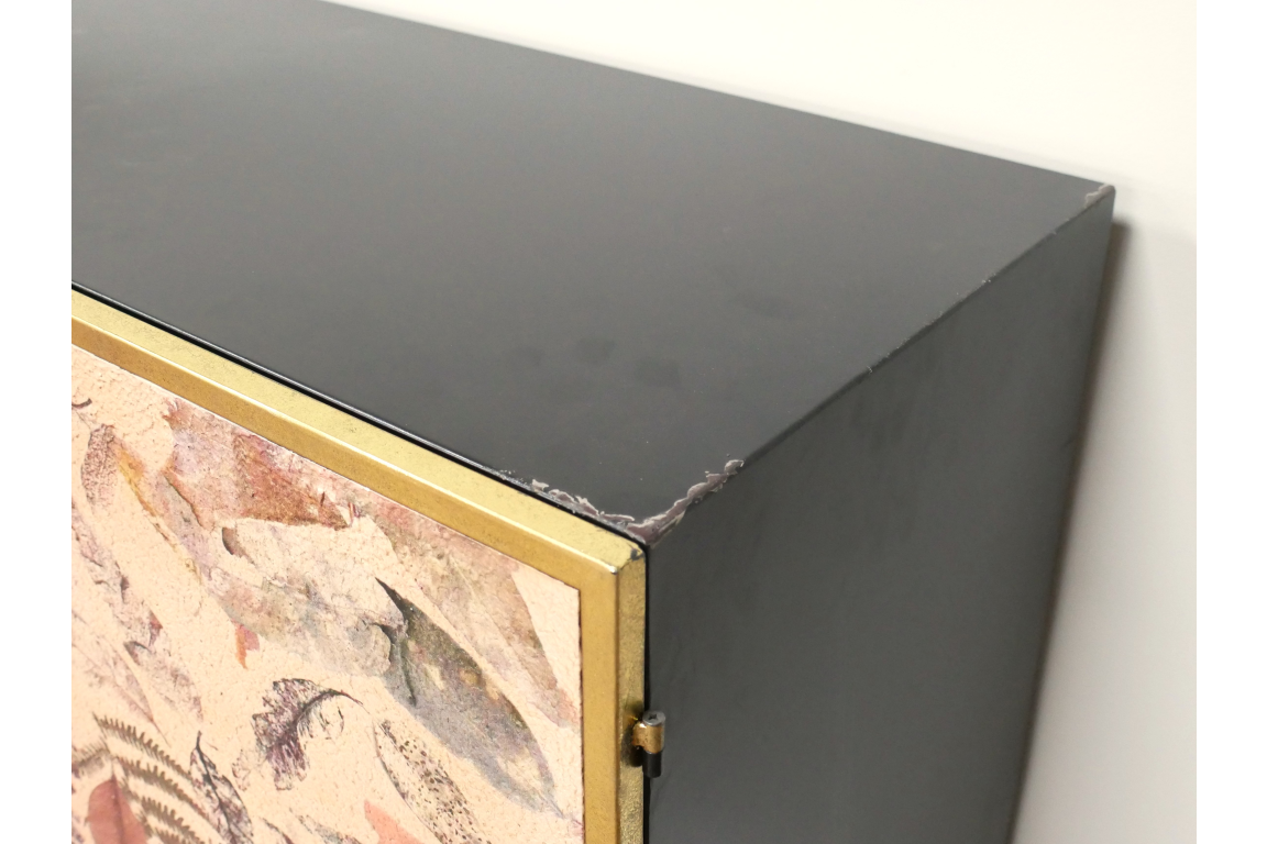 Large Leaf Cabinet with black metal body, brass trim, and decorative leaf-patterned front panel, corner view.