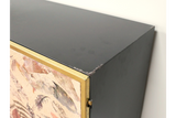 Large Leaf Cabinet with black metal body, brass trim, and decorative leaf-patterned front panel, corner view.