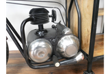 Close-up of motorbike bar cabinet black metal frame with silver metallic engine detail on wooden floor