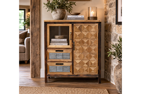 The rustic cabinet features a wooden frame with a geometric patterned door, a glass display section, and two gray drawers, perfect for stylish storage
