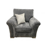 Grey fabric armchair with studded arms and patterned cream cushion