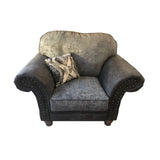 Grey fabric armchair with scroll arms, stud detailing, and decorative cushion front view