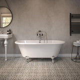 Freestanding white bath with chrome feet in modern bathroom with patterned tile floor
