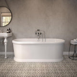 Freestanding white bathtub with chrome taps in modern bathroom with patterned floor tiles