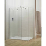 Frameless glass shower enclosure with chrome rainfall shower head on light tiled wall