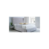 Grey upholstered bed frame with tall button-tufted headboard and mattress in modern bedroom