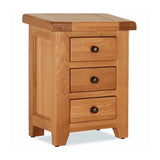 Oak bedside cabinet with three drawers and round metal handles, angled front view