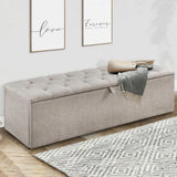 Beige fabric storage bench with tufted seat in modern entryway, throw blanket on top