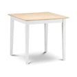 Square dining table with light wood top and white legs, shown from angle