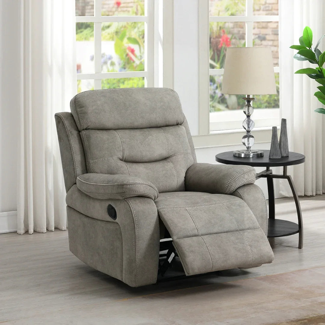 Cream armchair recliner with matching piping beside round black side table in bright living room