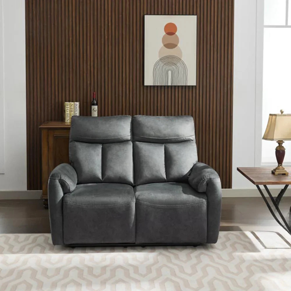 Dark grey recliner sofa on patterned rug with modern wooden wall and artwork background