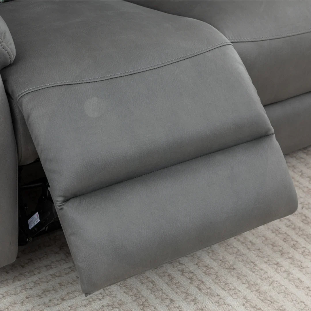 Charcoal grey recliner sofa footrest extended on patterned beige carpet