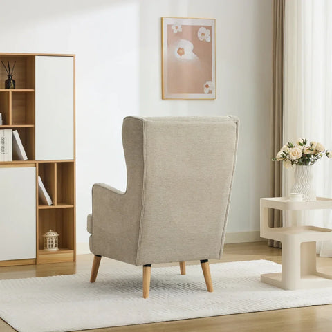Beige wing chair with wooden legs in modern living room corner with white rug and side table